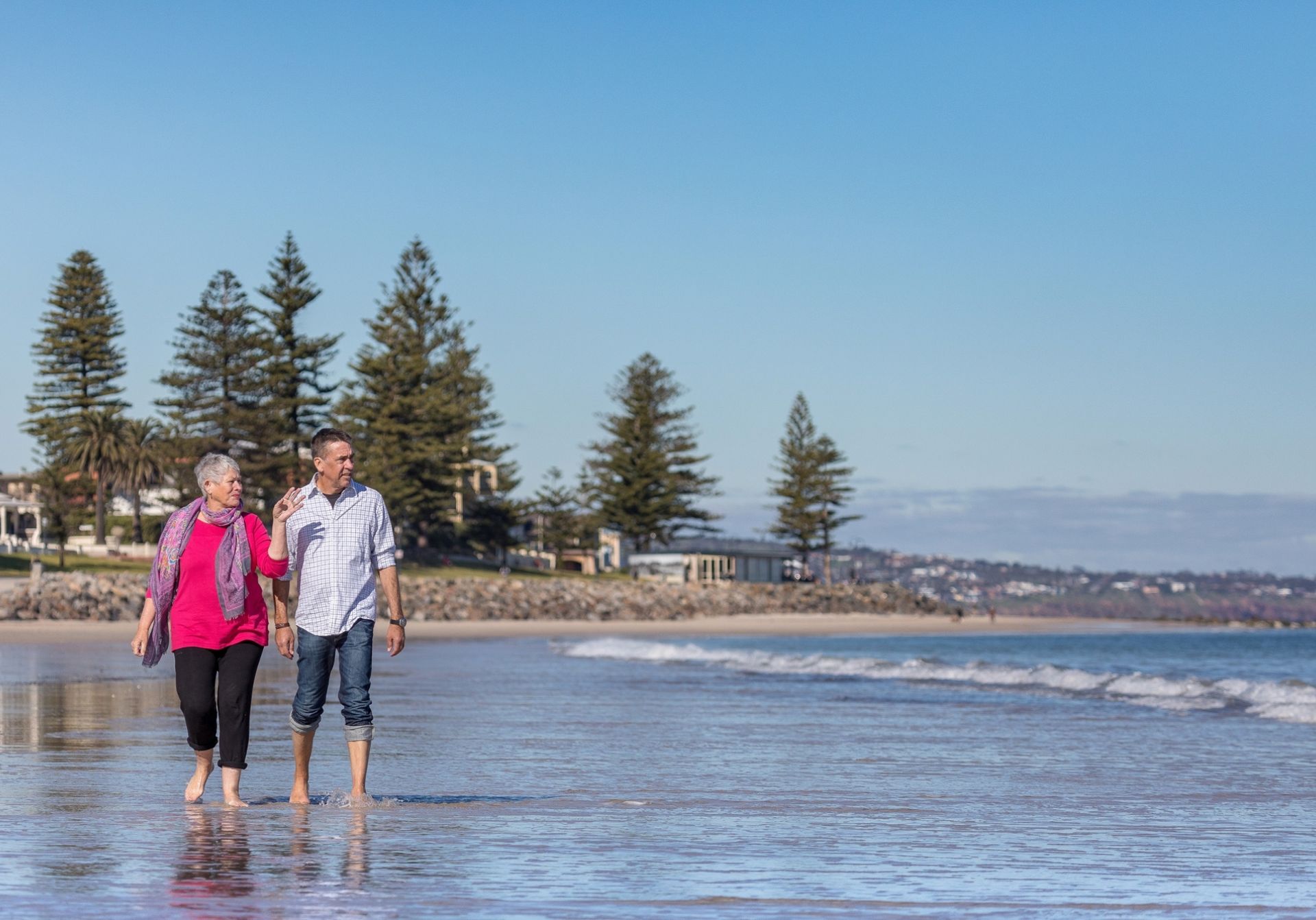 man and woman on beach with pines